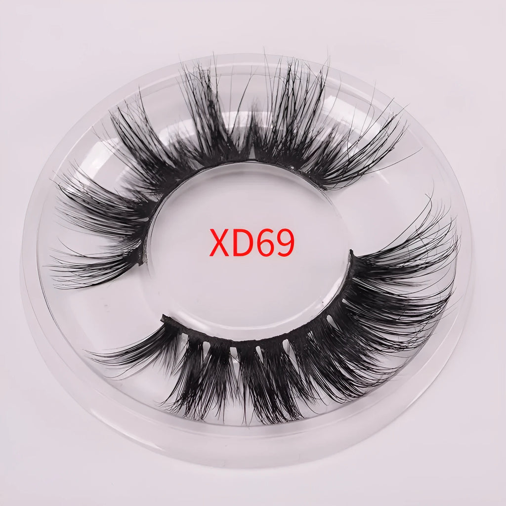 A pair of black 5D false eyelashes made from mink hair with an application brush and storage cap.