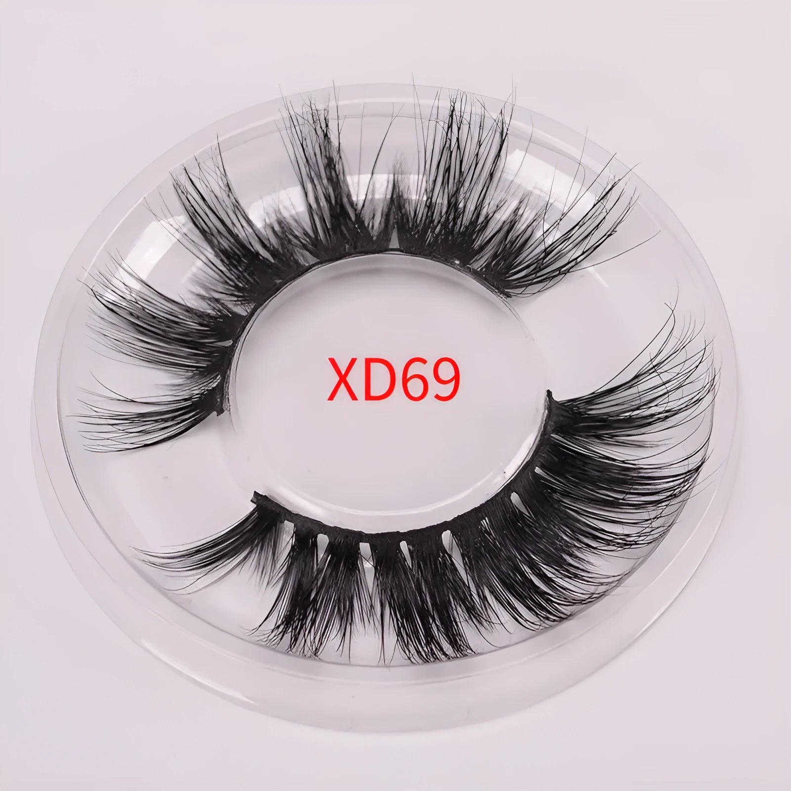A pair of black 5D false eyelashes made from mink hair with an application brush and storage cap.