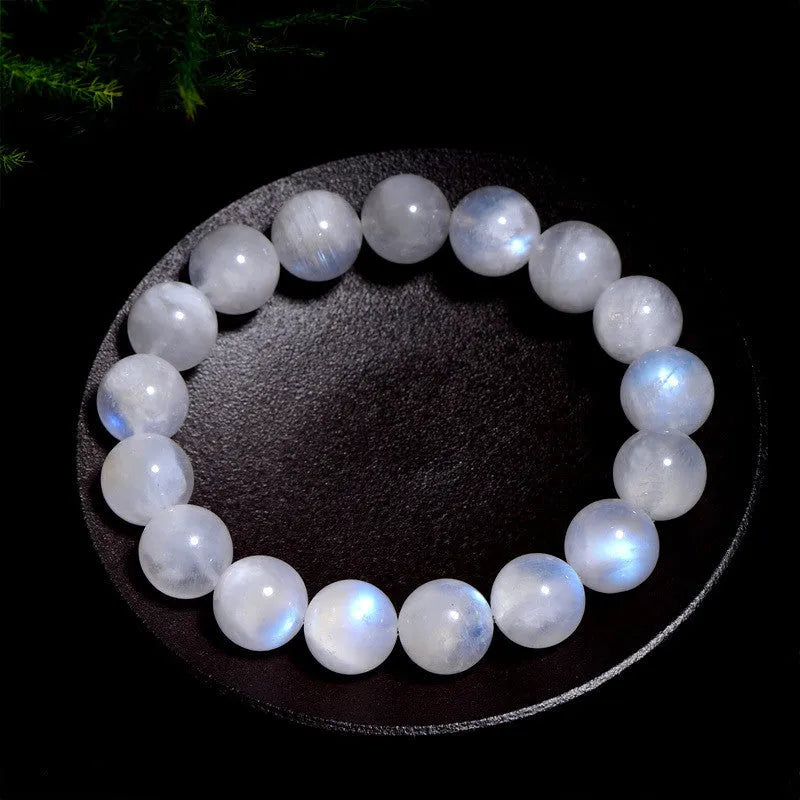 Natural blue moonlight round moonstone bead bracelet on a wrist, showing adjustable closure.