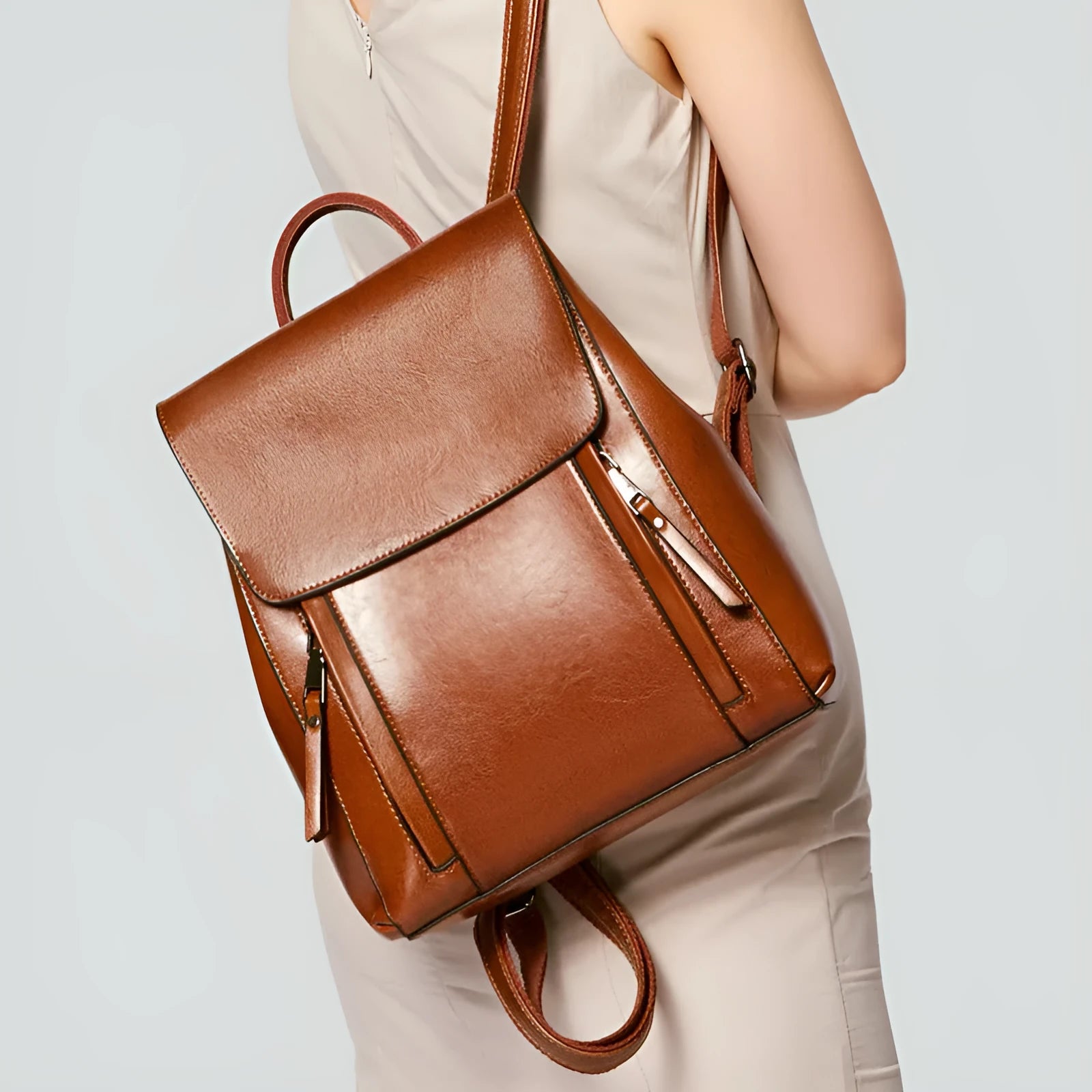 Genuine oil-waxed cowhide leather women's backpack in black, showing soft straps, cover flap, and clean stitching.