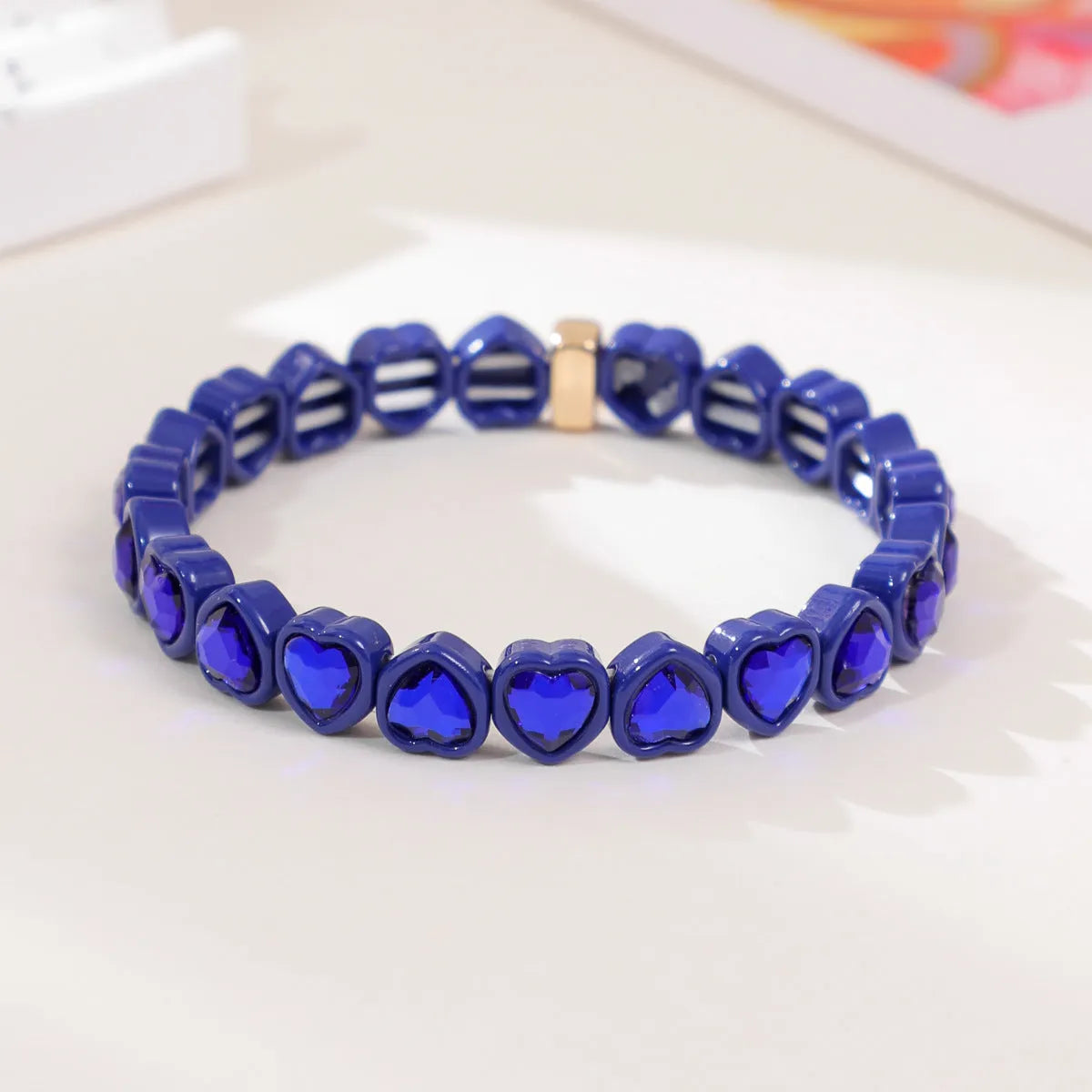 Rainbow enamel heart charm bracelet on alloy base with diamond treatment, stretch band, multicolour design.