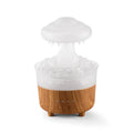 Wood grain white cloud-shaped humidifier diffuser with glowing LED lights and water droplets.