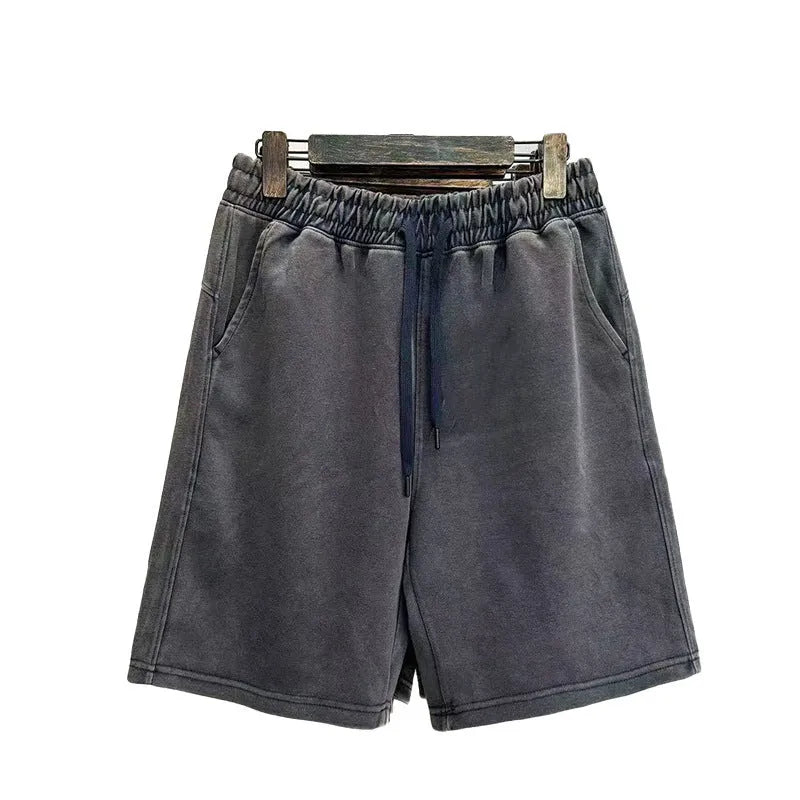 Men's loose-fit cotton shorts with a distressed finish in charcoal black, shown in a straight-leg style