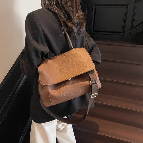 A brown PU tote bag with double shoulder straps and visible sewing thread detail.