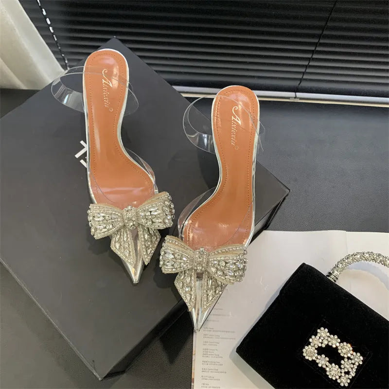 Silver women's bow rhinestone pointed transparent high heel sandals on display
