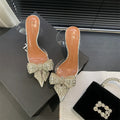 Silver women's bow rhinestone pointed transparent high heel sandals on display