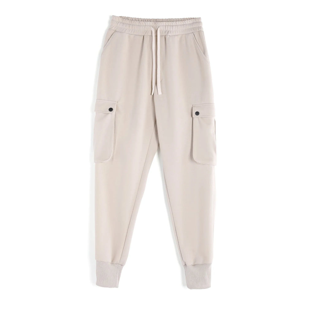Men's beige ankle-tie loose-fit casual cotton trousers with side pockets on a neutral background.