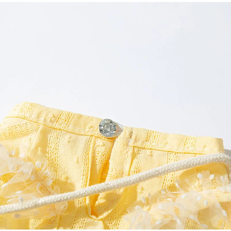 Two-tone sleeveless pet outfit in yellow or blue with ruffles, matching bow and small woven crossbody bag.