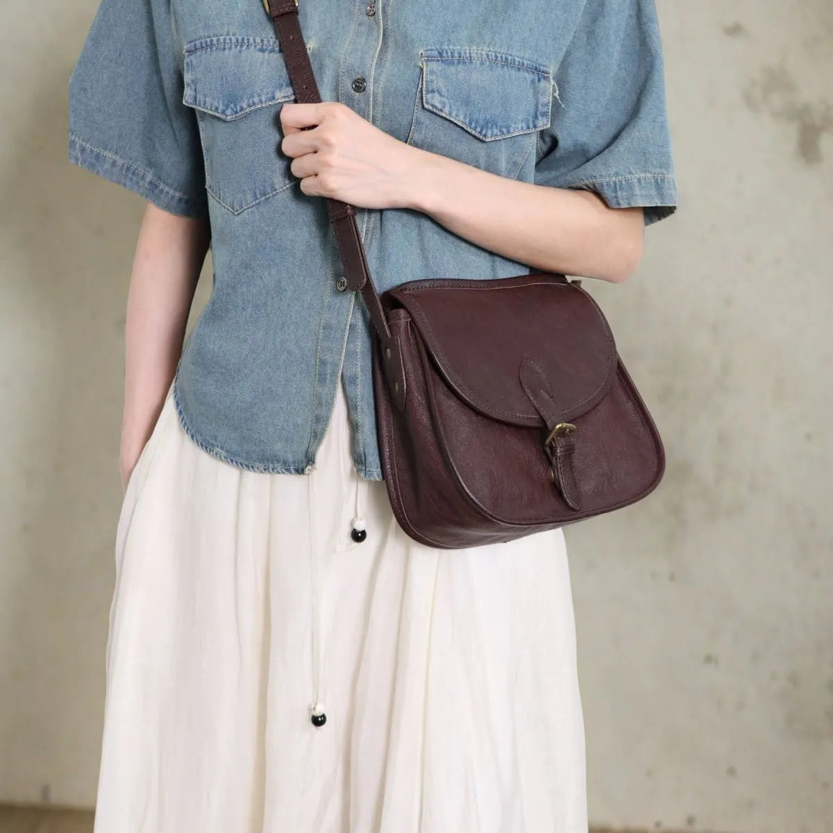 Brown genuine leather messenger bag with flap closure and crossbody strap showing internal organiser compartments