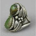 Close-up of a women's geometric turquoise alloy ring on a grey background.