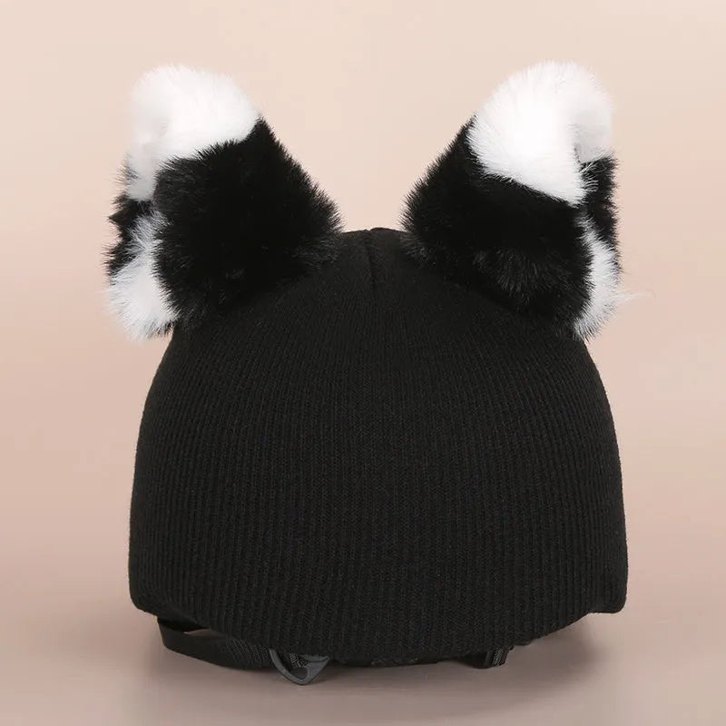 Colourful plush cartoon hat decoration sitting on top of a ski helmet