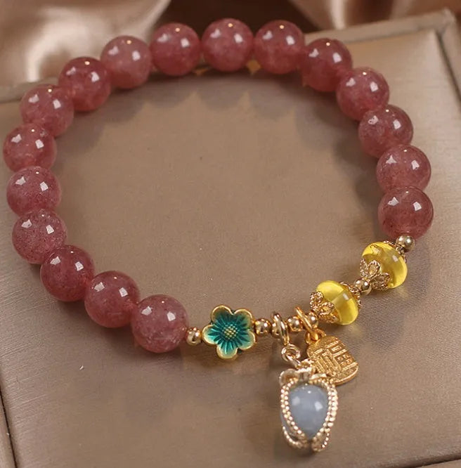 Red strawberry quartz beaded bracelet with metal alloy setting and sparkling rhinestone details.