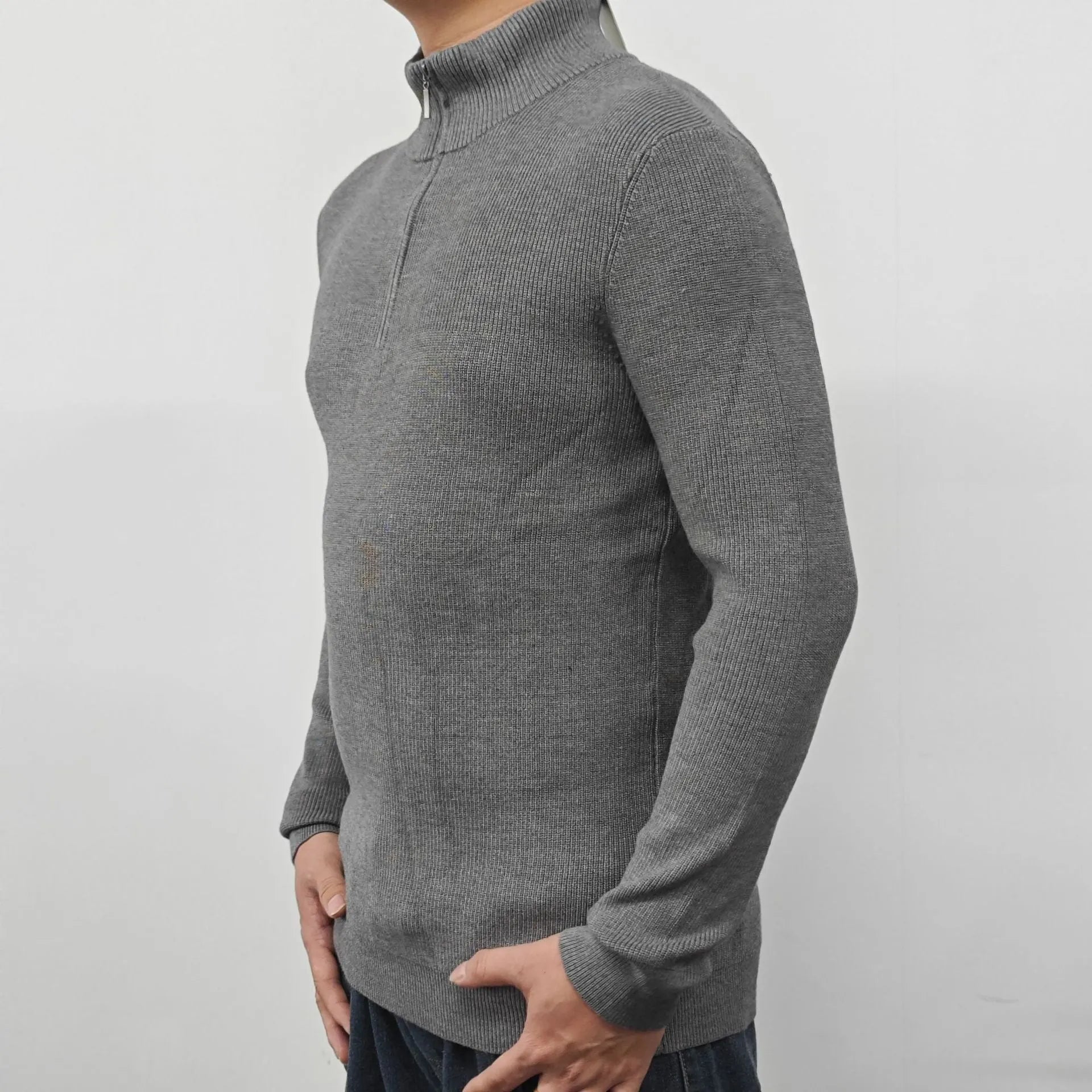 Man wearing a grey half-turtleneck zip-front sweater, a cotton blend pullover for casual wear.