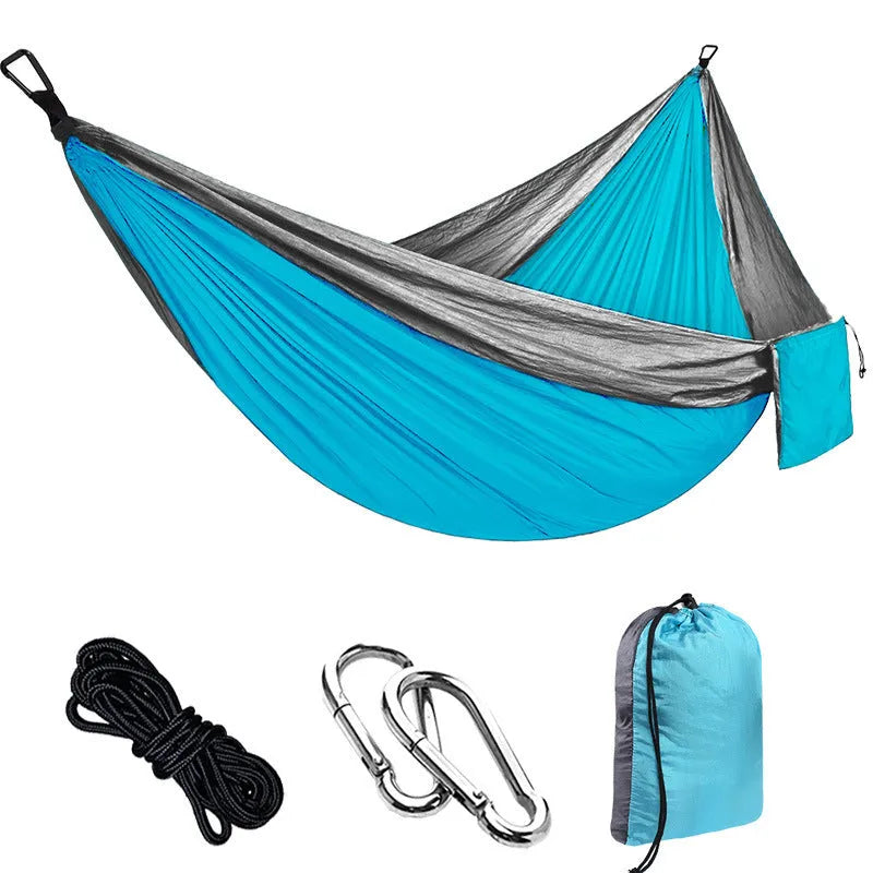 Parachute cloth double camping hammock with black buckles and ropes on green background