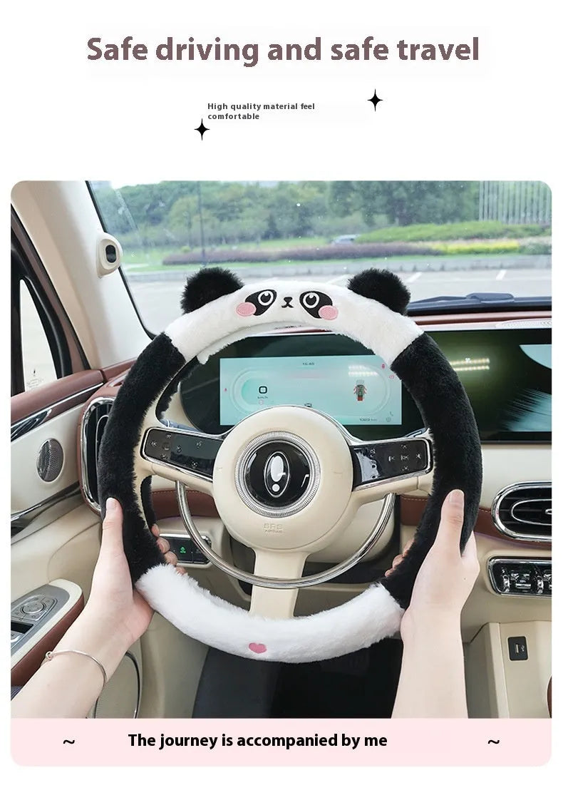 Plush furry steering wheel cover with embroidered panda face, fitted on a car steering wheel.