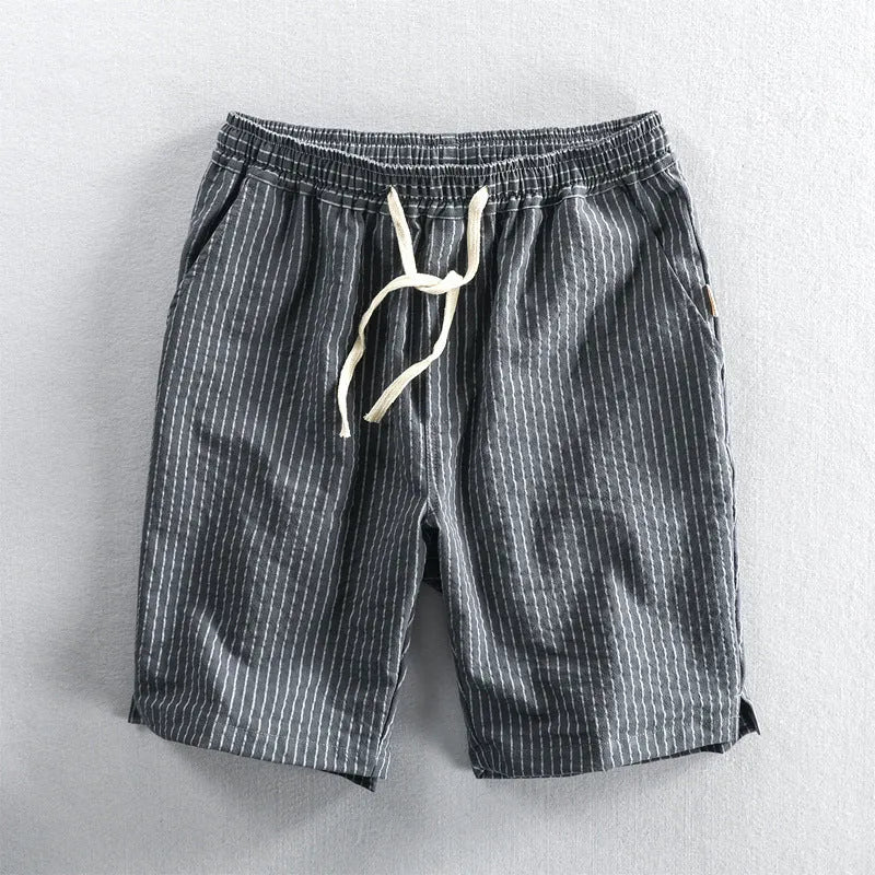 Man wearing black and white striped casual cotton shorts with a loose straight-leg fit.