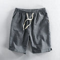 Man wearing black and white striped casual cotton shorts with a loose straight-leg fit.