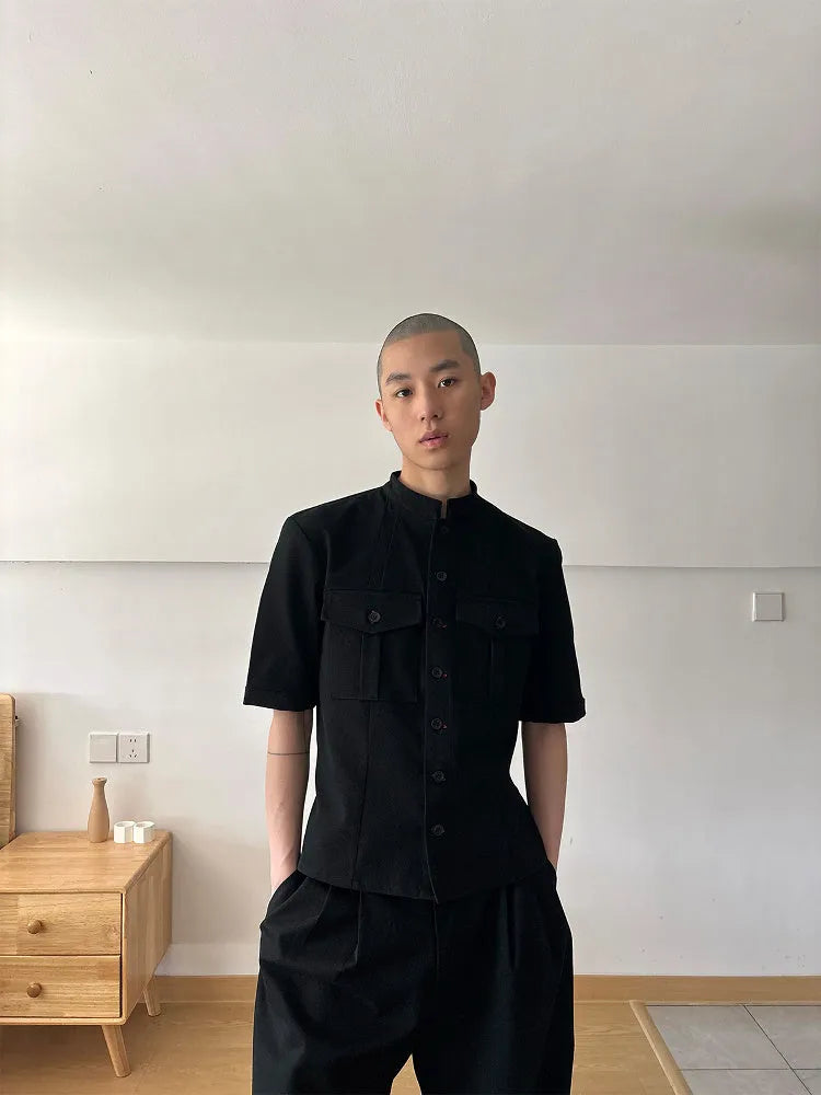 Handmade black half-sleeve hunting shirt with a shirt collar on a hanger.