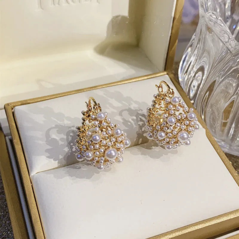 Gold tone women's flower basket earrings with small rice-shaped beads and pearl inlay detail