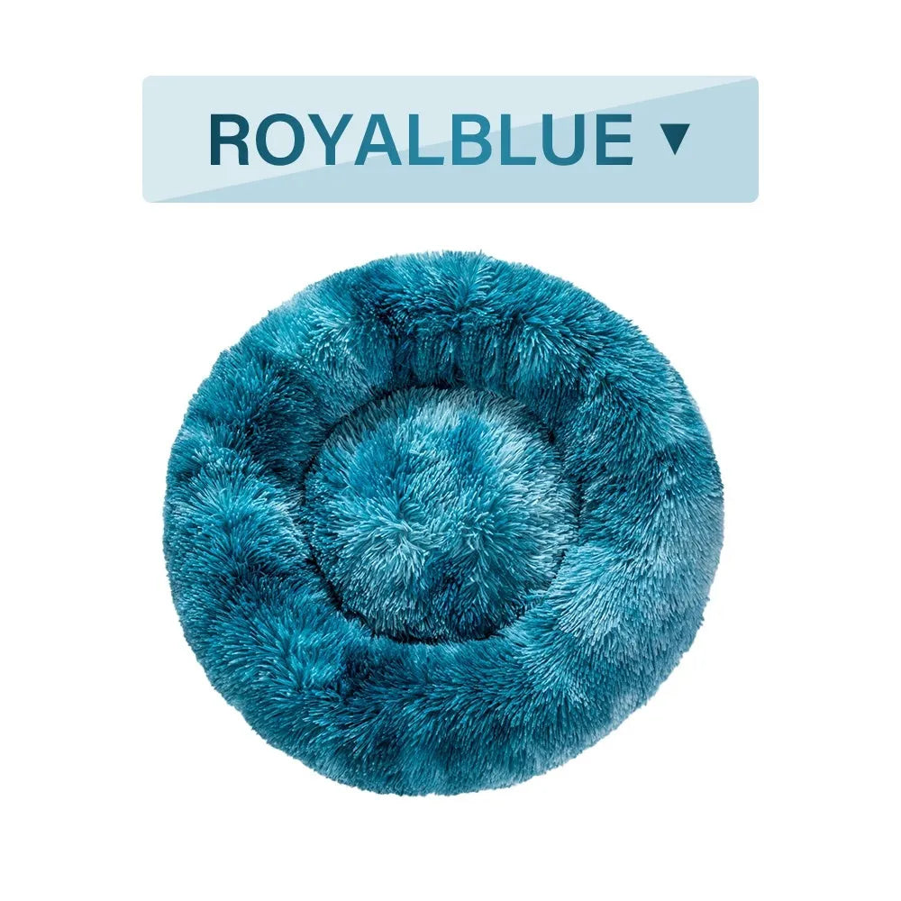 A fluffy, round donut-shaped dog bed with a raised rim in long plush fabric.