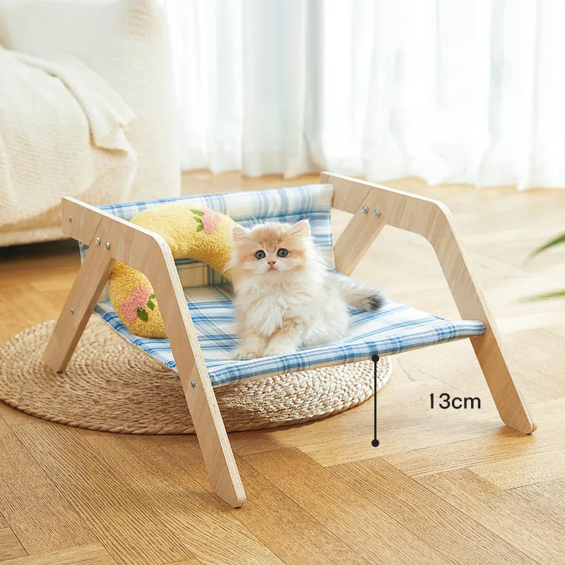 Elevated wooden cat bed with blue cloth hammock in beach chair style