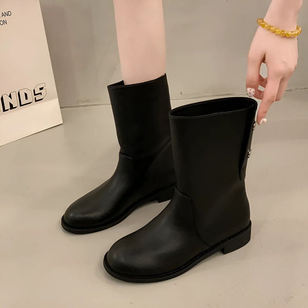 Women's black leather mid-calf platform boots with silver stud details on a white background