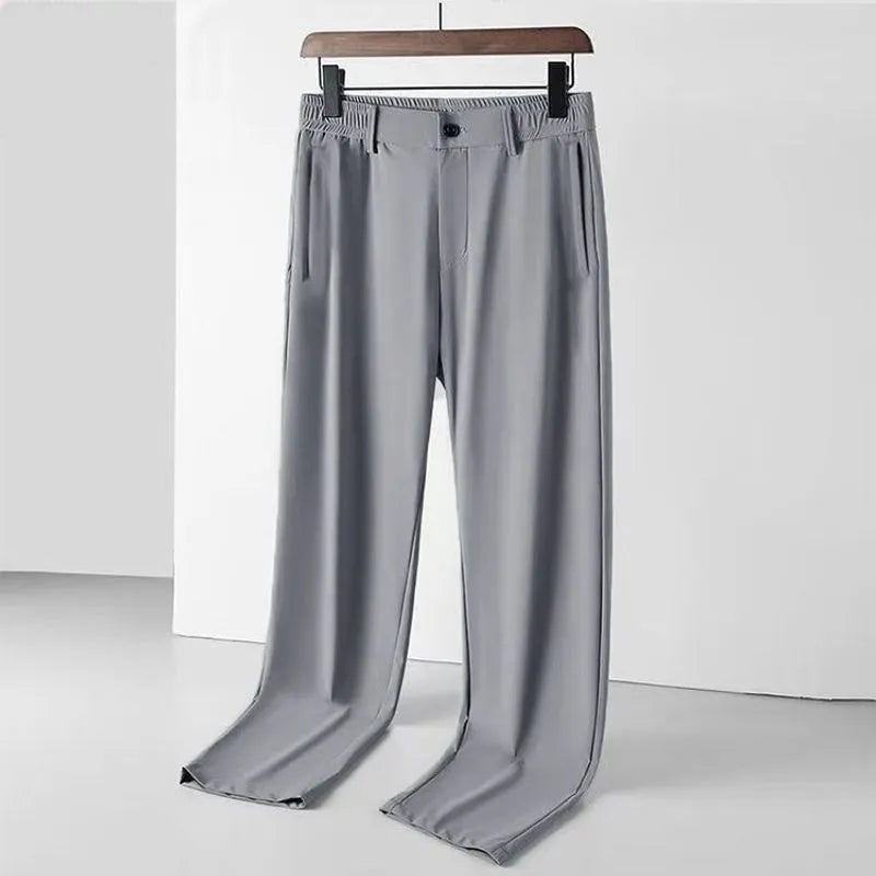 Man wearing black ice silk straight-leg loose casual trousers with an elastic waist.