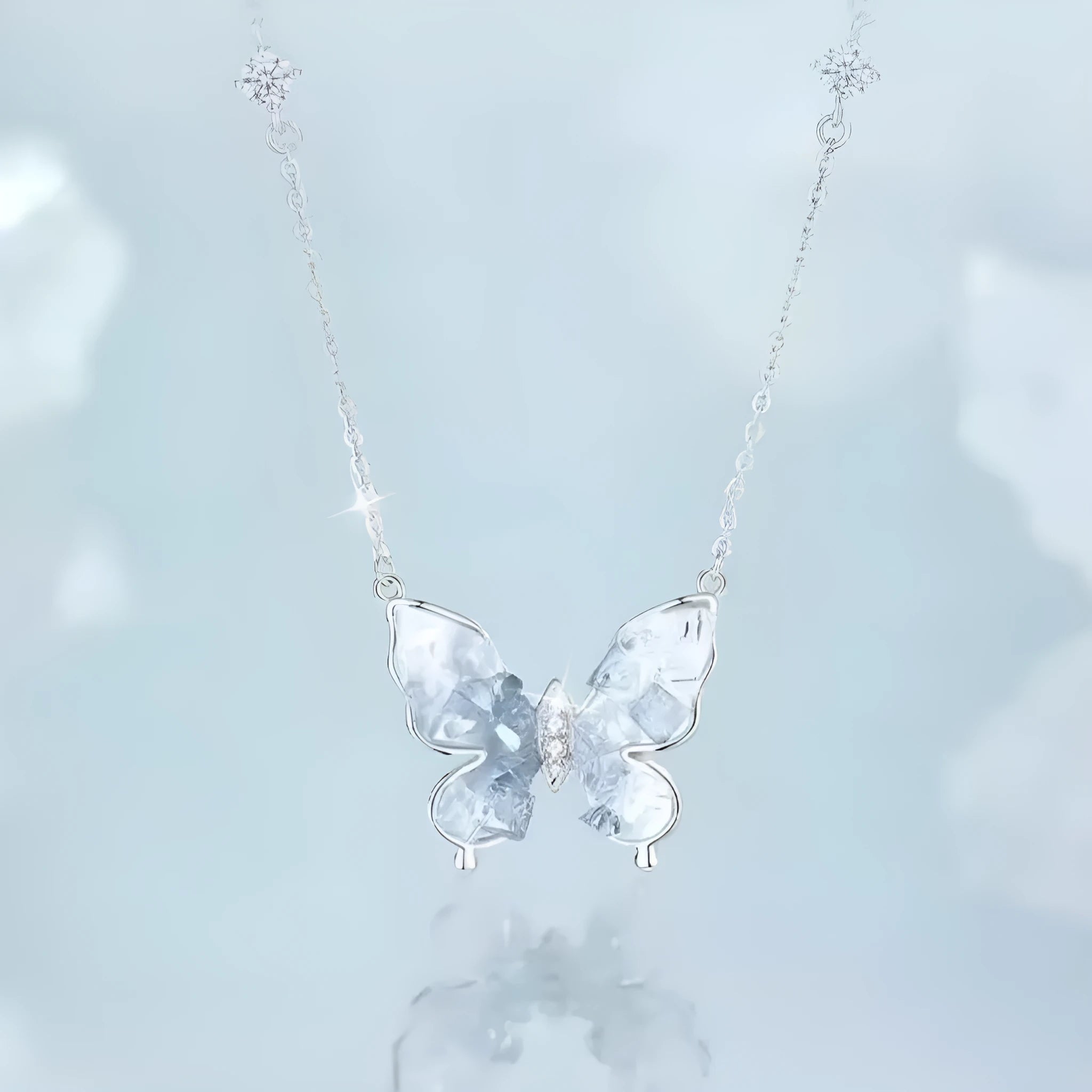 Close-up of a silver butterfly pendant on an adjustable O-ring chain, showing detailed wings and a 41-50 cm length.