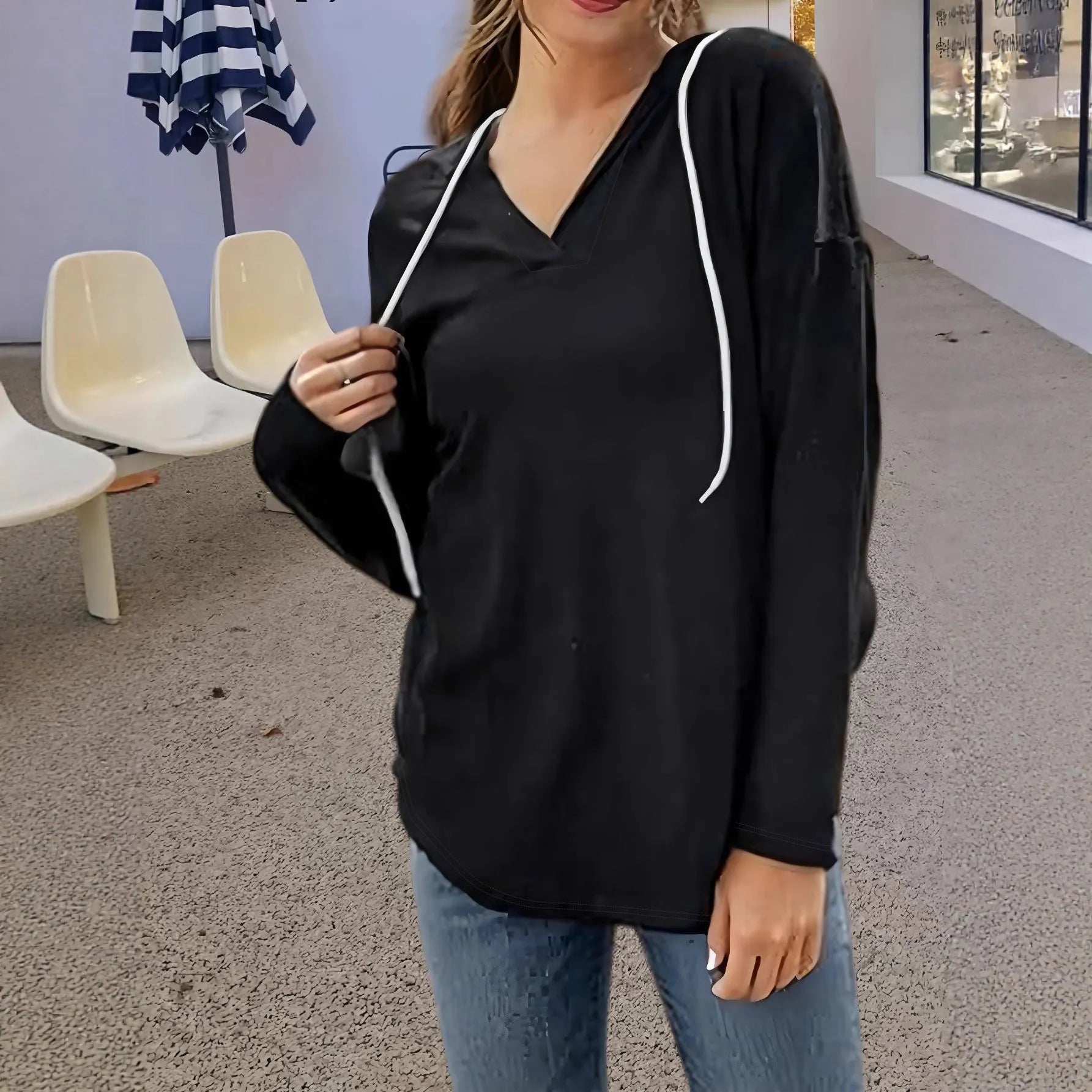 Women's loose fit black hooded V-neck sweatshirt with long sleeves on a hanger.