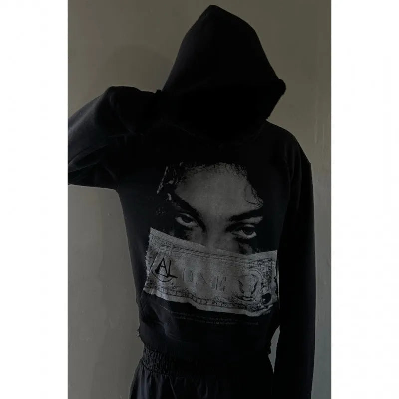 Black women's loose-fit hoodie with a cartoon print, shown in a casual setting.