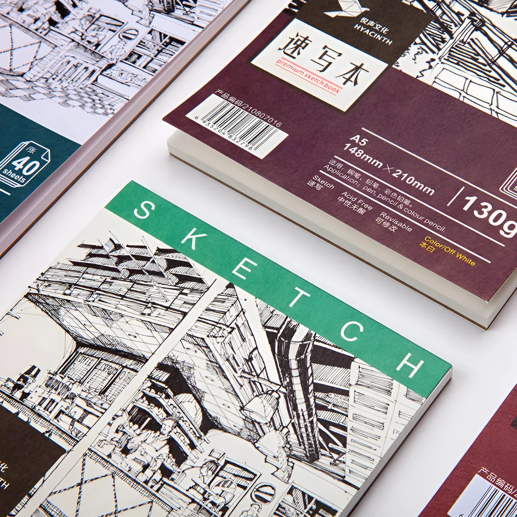 A sketchbook open on a table, showing coil binding and heavy-weight paper suitable for drawing.