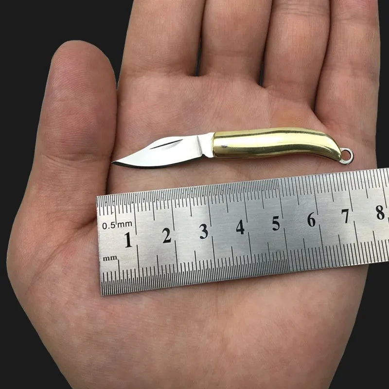 Brass mini folding knife keychain pendant with 3cm blade open showing brass body and compact size
