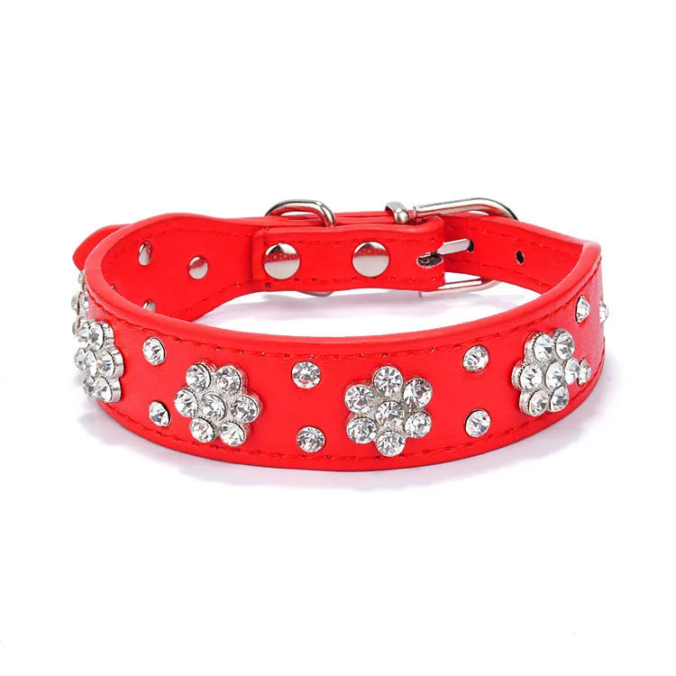 A black PU leather dog collar decorated with sparkling rhinestone flowers and metal studs, showing the adjustable eyelets and metal D-ring.