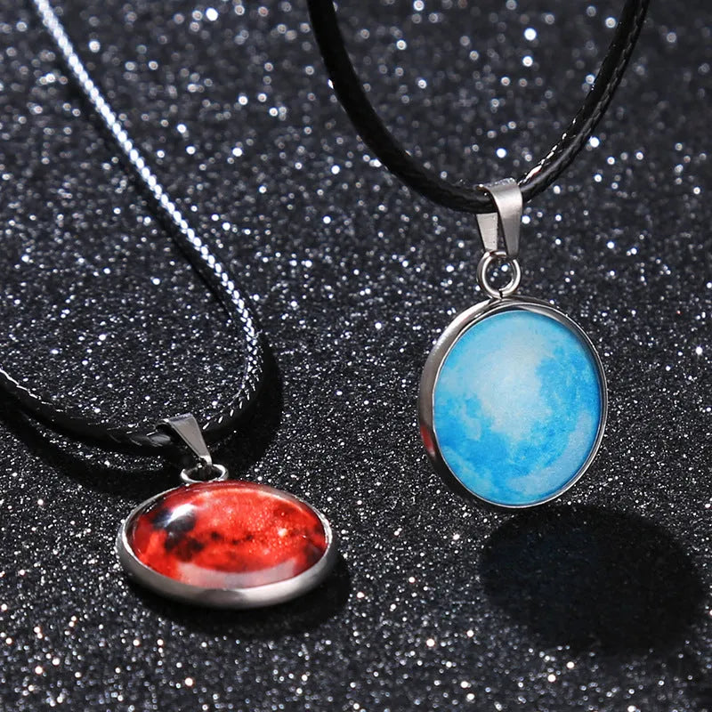 Luminous moon and star constellation pendant necklace with a silver-tone chain on a black background.