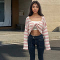 Woman wearing a striped long-sleeve sweater in mercerised cotton, showing front and back wearability with exposed navel detail.