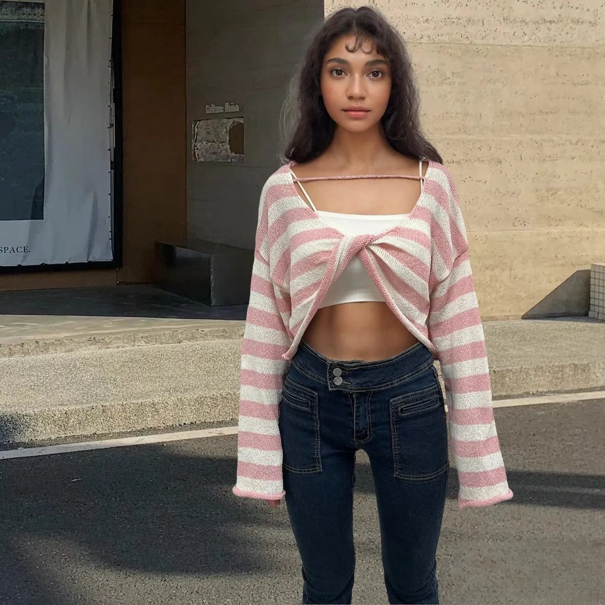 Woman wearing a striped long-sleeve sweater in mercerised cotton, showing front and back wearability with exposed navel detail.