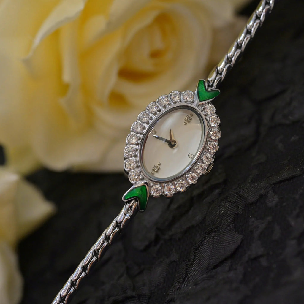 European small gold women's watch with handmade rhinestone inlay on a white background