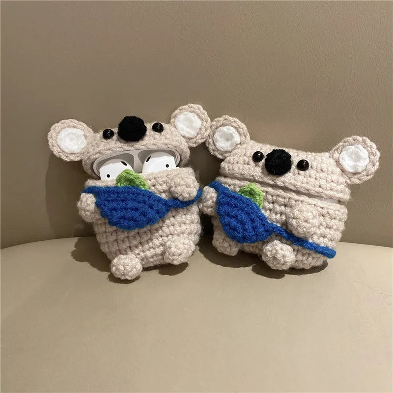 Hand-knitted grey koala bear backpack design earphone cover for Apple AirPods on a table.