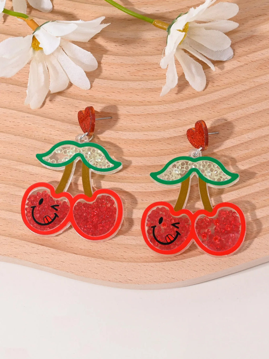 Colourful acrylic drop earrings with fruit and dessert charms including strawberry, cherry, pineapple, and watermelon.