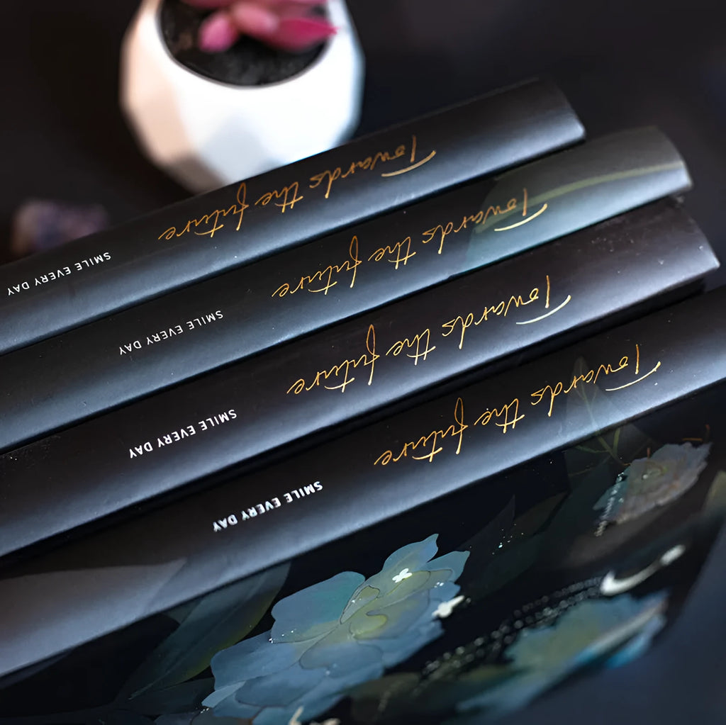 A5 notebook with luminous cover showing colour options: deep blue, gold, light blue, purple with internal colour illustrations