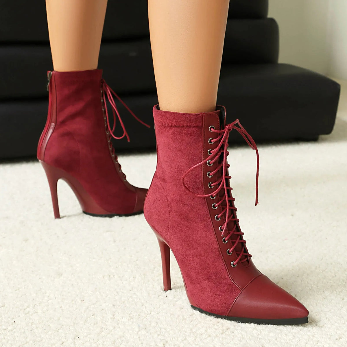 Women's suede pointed toe ankle boots with stiletto heel, back zip, and drawstring patchwork detail in black, brown, or wine red.