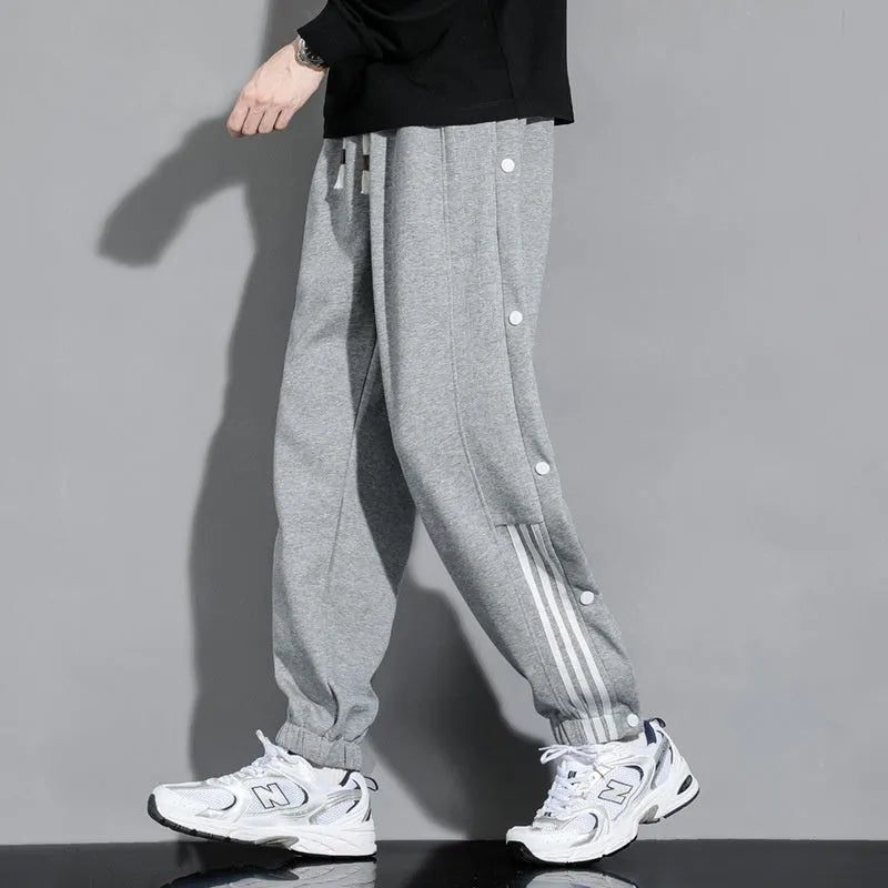 Men's black loose-fit ankle-tied sports trousers with high waist and drawstring closure on mannequin