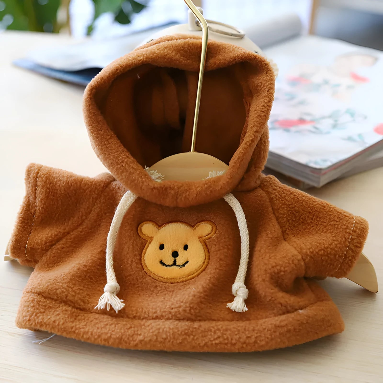 A blue cloth hoodie sweater for a small dog, showing the hood up.