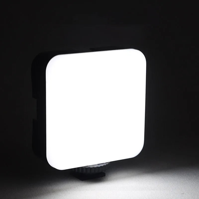 Compact black LED mini square camera flash with rotatable head on a small tripod stand