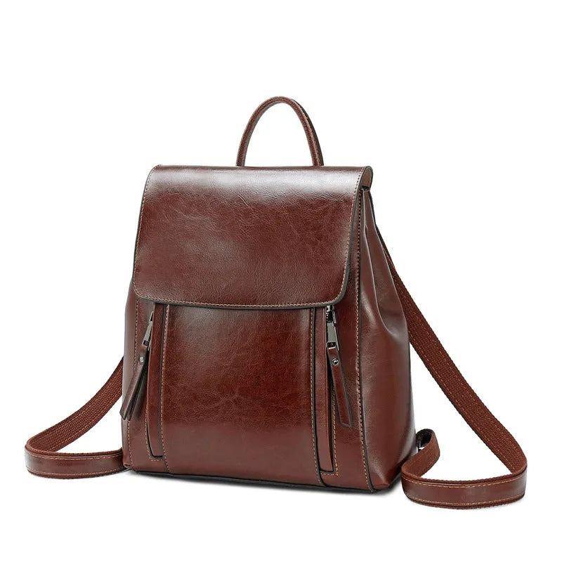 Genuine oil-waxed cowhide leather women's backpack in black, showing soft straps, cover flap, and clean stitching.