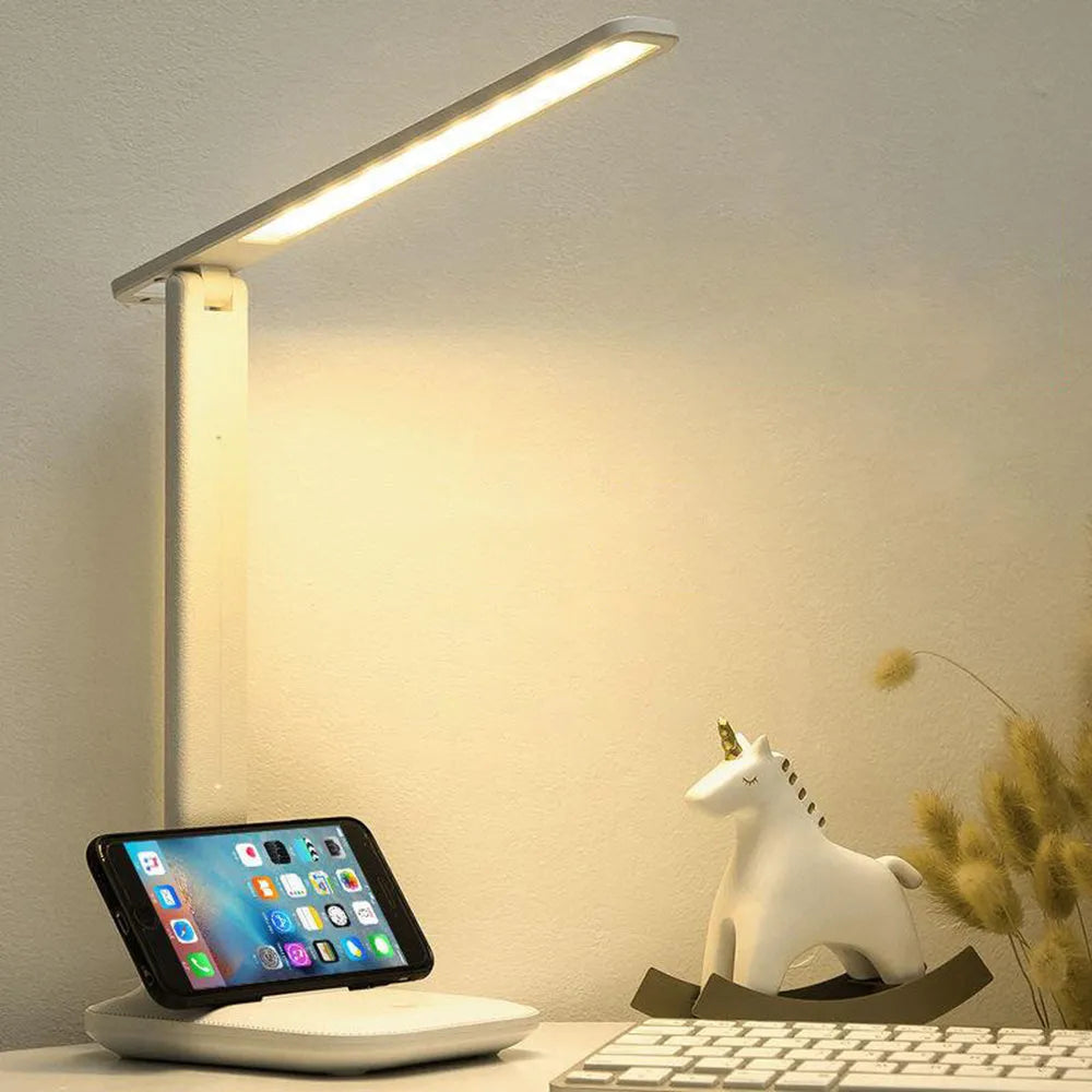 White plastic bedside lamp with touch dimming and colour-changing LED light on a table.
