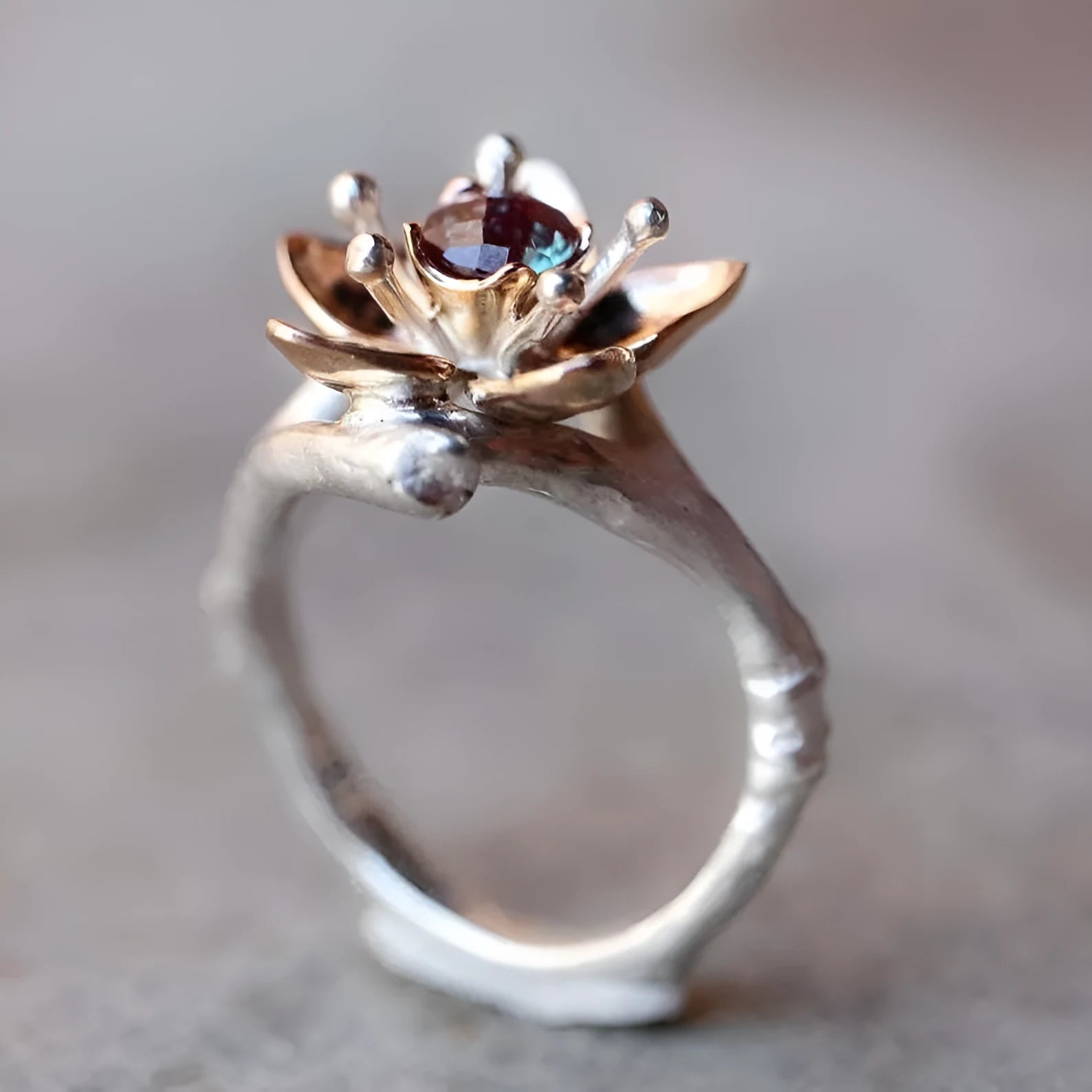 Geometric silver two-tone women's ring with open floral detail on a plain background.
