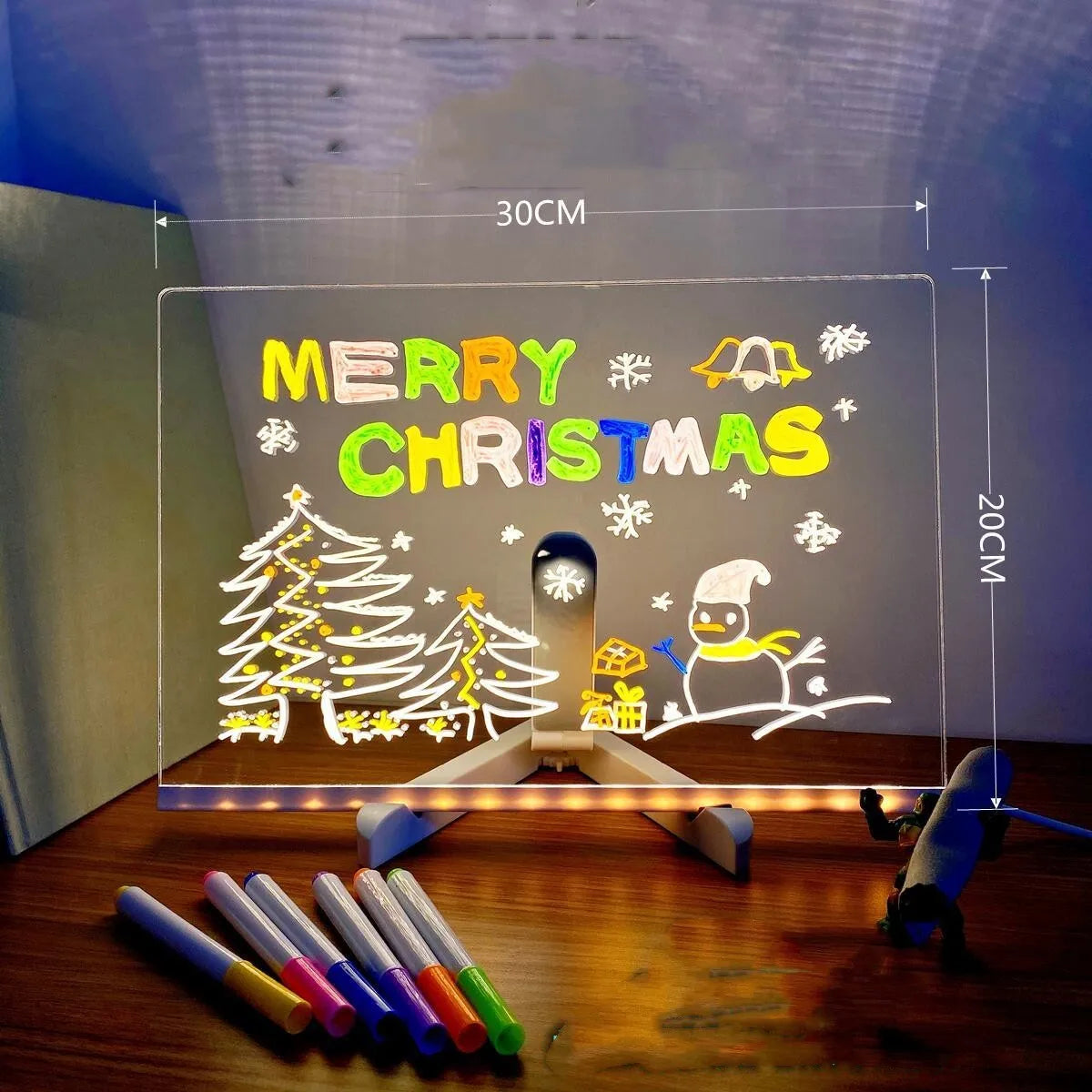 DIY acrylic message board LED night light on desk with colourful writing, USB cable, and pens