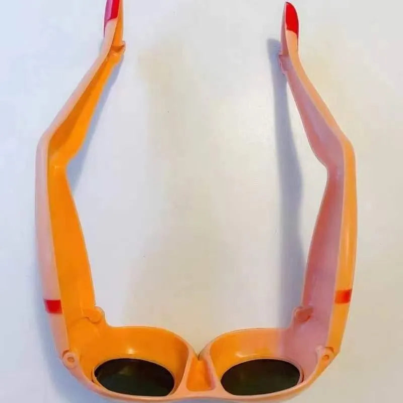 Orange plastic novelty sunglasses shaped like a pair of legs, on a white background.