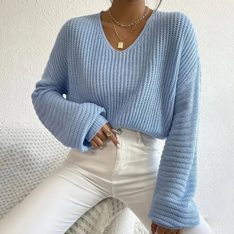 Women's solid colour long sleeve loose pullover in polyester fabric on a hanger.